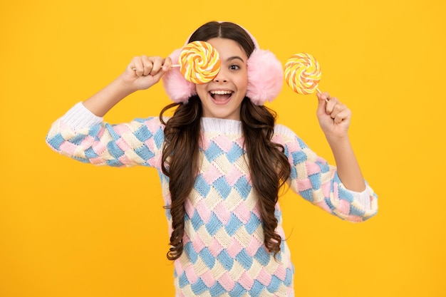 Enfant adolescent cool avec sucette sur fond jaune isolé Douce vie d'enfance Teen girl with yummy lollipop candy