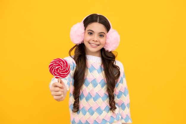 Enfant adolescent cool avec sucette sur fond jaune isolé Douce vie d'enfance Teen girl with yummy lollipop candy