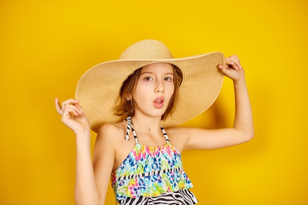 Enfant adolescent fille en maillot de bain et chapeau de paille posant