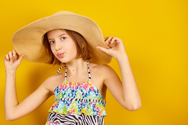 Enfant adolescent fille en maillot de bain et chapeau de paille posant