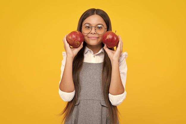 Photo enfant adolescent avec pomme sur fond jaune isolé les pommes sont bonnes pour les enfants bonne fille face à des émotions positives et souriantes