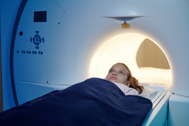 Enfant adorable se déplaçant dans la machine de balayage d'irm avant l'examen