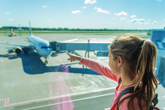 Un enfant à l'aéroport regarde l'avion. Mise au point sélective. Enfant.