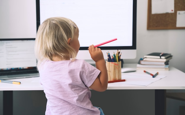 Enfant d'âge préscolaire utilisant un ordinateur au début du développement ou du divertissement à la maison