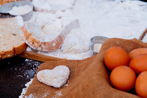 enfant aidant maman à cuisiner pour la Saint-Valentin. Préparation d'un ingrédient avec de la poudre et de la farine. Cuisine sale et désordonnée.