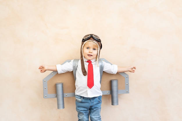 Enfant avec des ailes de papier jouant à l'intérieur