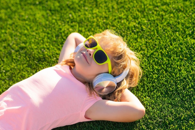 L'enfant aime écouter de la musique dans des écouteurs rêver l'enfant aime écouter de la musique dans des écouteurs