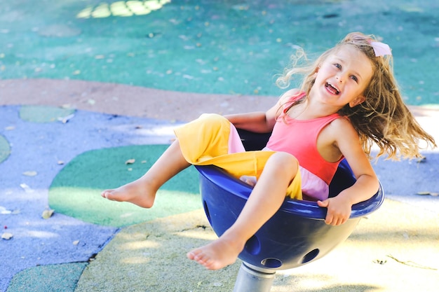 Enfant sur une aire de jeux extérieureJeu d'enfant dans un parc d'été coloré et ensoleillé