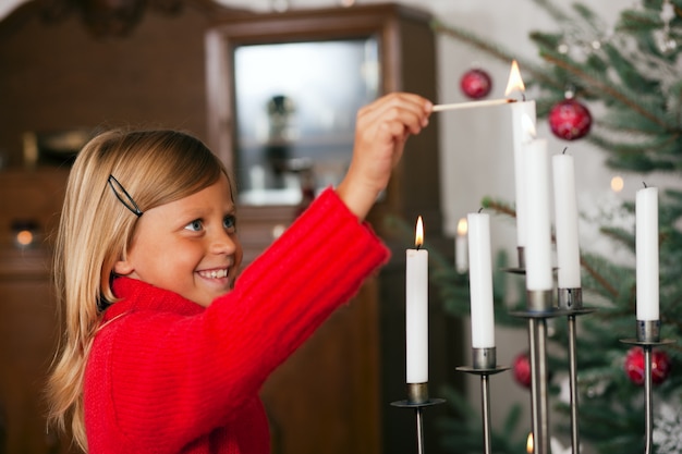 Enfant allumant des bougies de Noël