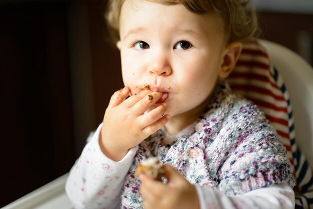 L'enfant d'un an mange et met les doigts dans sa bouche