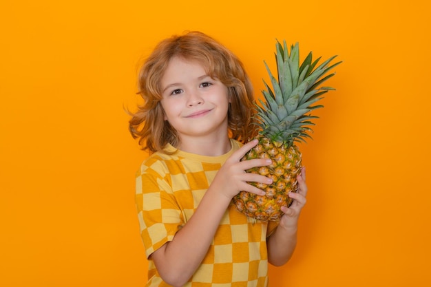 Enfant avec ananas en studio Studio portrait d'enfant mignon tenir ananas isolé sur fond jaune