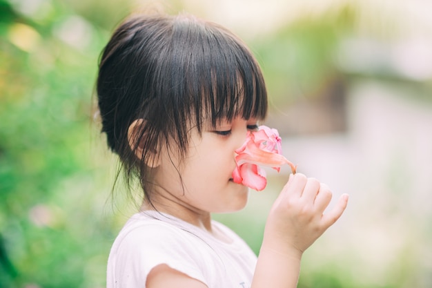 enfant apprenant l'odorat d'une fleur