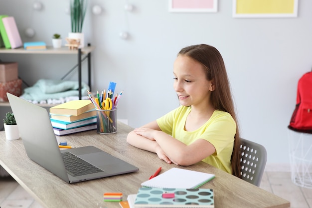 Un enfant apprend en ligne à la maison grâce à un ordinateur portable moderne sur Internet