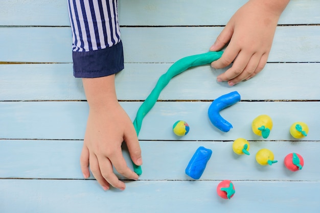 Enfant à l&#39;argile et à la créativité pour faire des lignes et des fruits