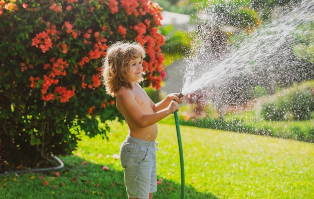 L'enfant arrose la plante à l'extérieur de la maison concept d'activité d'apprentissage de la culture des plantes pour les enfants et l'éducation des enfants pour la nature