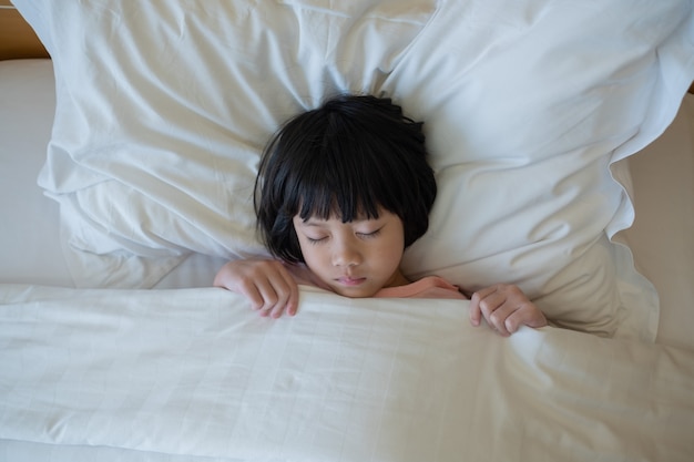 enfant asiatique dormir sur le lit, enfant malade