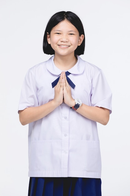 Enfant asiatique fille en uniforme d&#39;étudiant, acteur sawaddee signifie Bonjour.