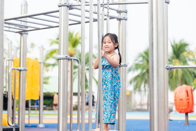 Enfant asiatique jouant sur une aire de jeux extérieure heureux petit enfant d'âge préscolaire s'amusant en jouant