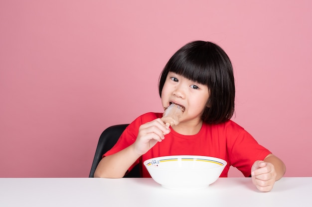 Enfant asiatique mangeant la crème glacée, saison d'été