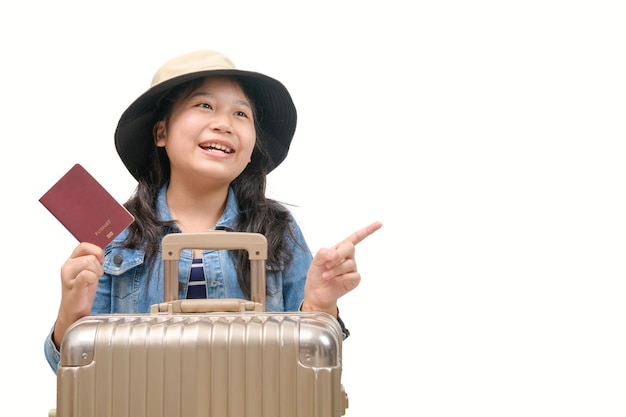 Enfant asiatique mignon prêt à voyager portant un chapeau et tenant son passeport avec des bagages isolés sur fond blanc, nouveau concept normal