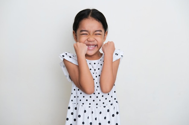 Enfant asiatique poing serré et montrant une expression excitée