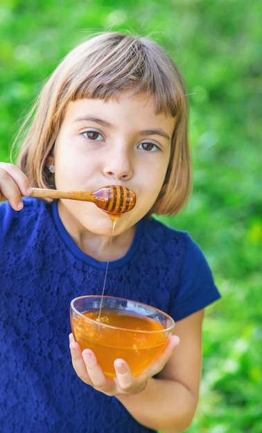 Enfant une assiette de miel dans les mains