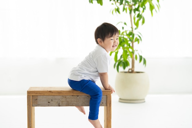 Enfant assis sur une chaise et gambader avec le sourire