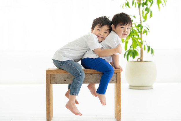 Enfant assis sur une chaise et gambader avec le sourire