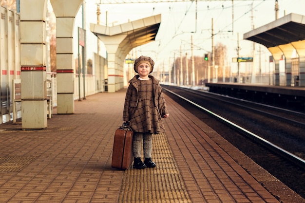 Enfant en attente d'un train à la gare