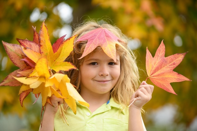 Enfant d'automne avec des feuilles d'automne sur fond de nature d'automne portrait d'enfant avec des feuilles d'automne en plein air je