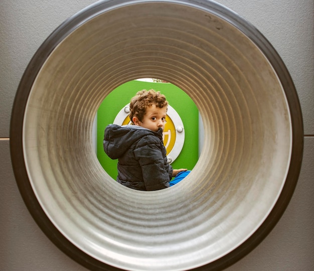 Photo enfant de l'autre côté du tunnel dans l'aire de jeux