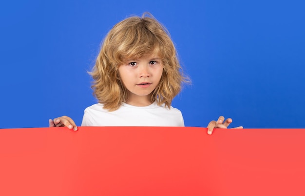 Enfant avec une bannière blanche rouge sur le fond du studio panneau d'affichage publicitaire copier l'affiche de l'espace pour