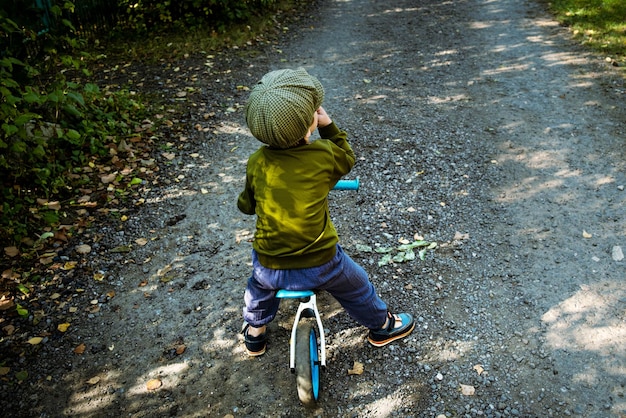 Un enfant en bas âge actif fait du vélo d'équilibre le long d'un sentier