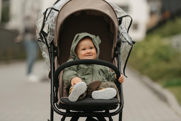 Un enfant en bas âge féminin s'assied dans la poussette un jour nuageux