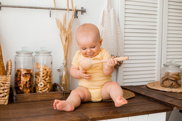 Enfant en bas âge mignon dans la cuisine en bois de la maison