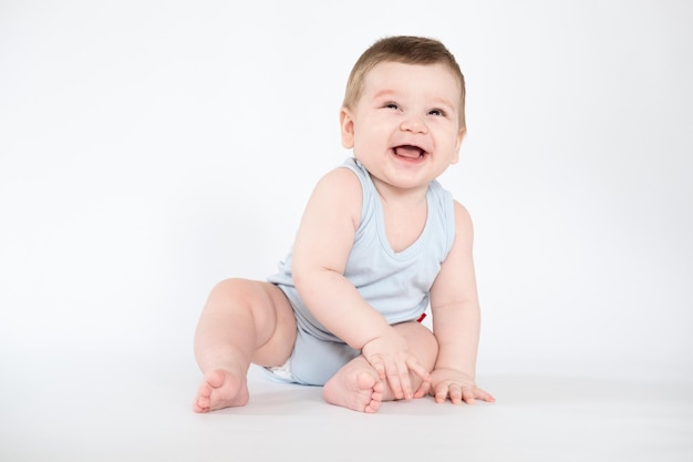 Enfant bébé garçon assis garçon souriant heureux sur un fond de mois blanc