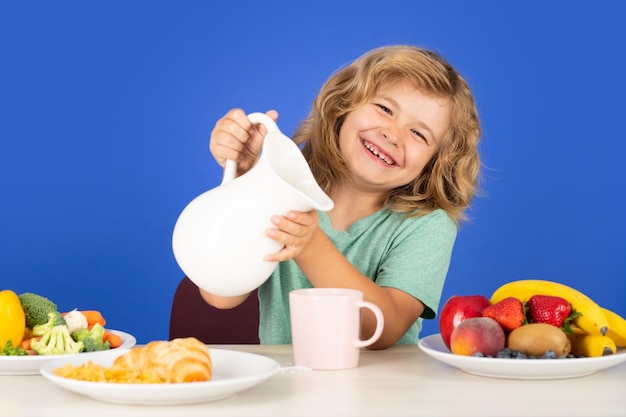 Enfant boit du lait laitier mignon enfant buvant du lait sur fond bleu