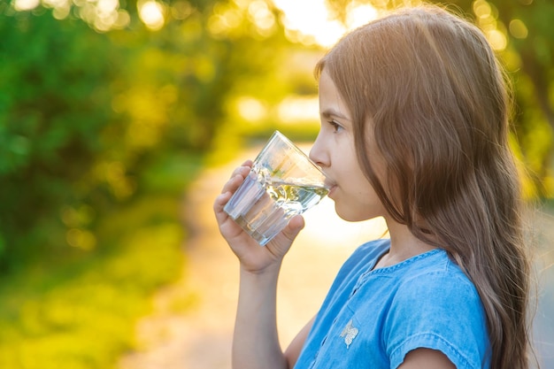 L'enfant boit de l'eau d'un verre Mise au point sélective