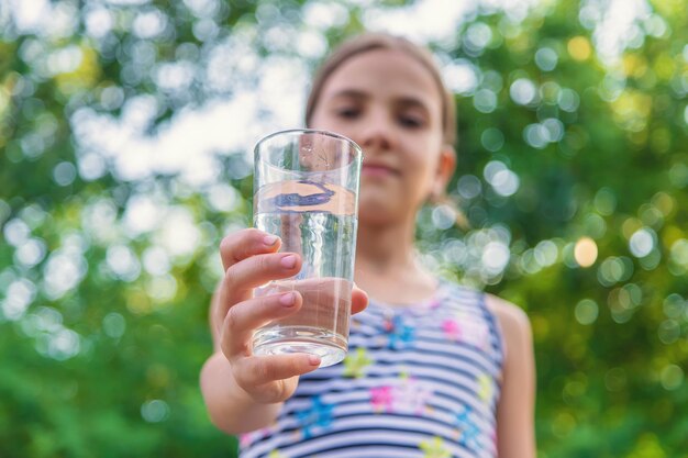 L'enfant boit de l'eau d'un verre Mise au point sélective