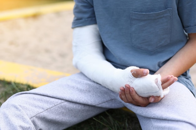 Un enfant a le bras cassé un petit garçon avec un membre fracturé à l'extérieur blessure de fracture en été