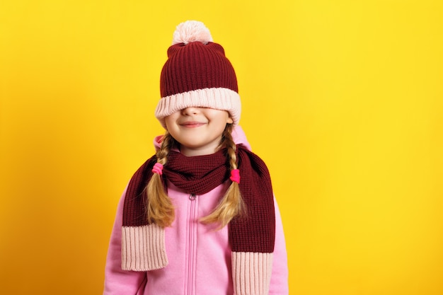 Enfant cache ses yeux sous un chapeau