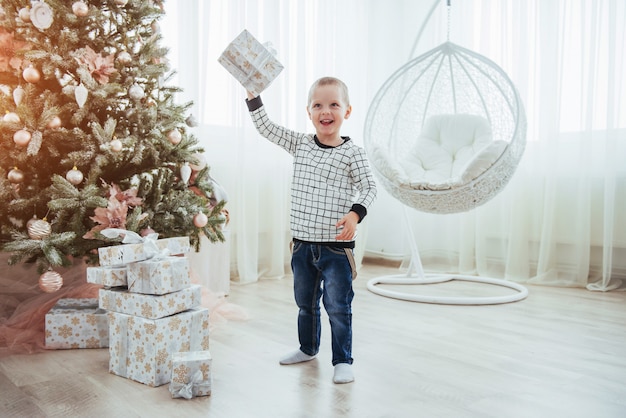 Un enfant avec un cadeau dans un beau salon lumineux