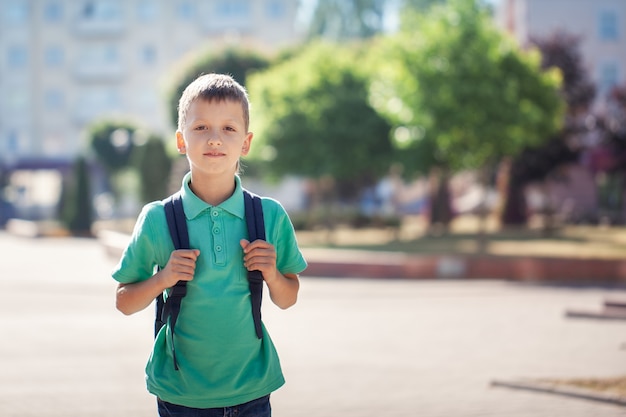 Enfant avec cartable. Kid à l'extérieur.