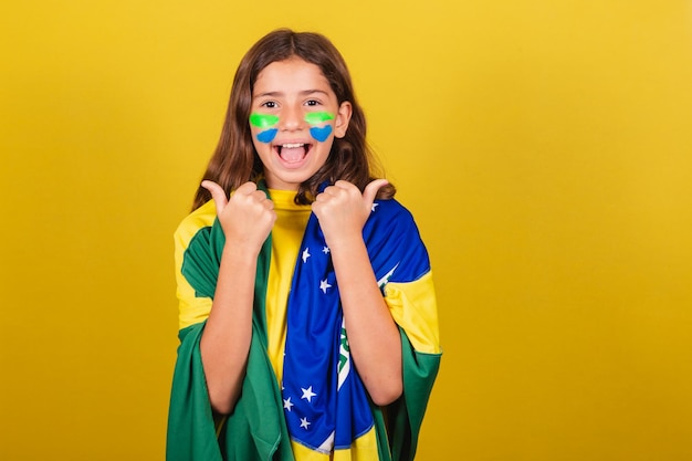 Enfant caucasien brésilien fan de football pouce vers le haut approuvant l'approbation affirmative des Jeux Olympiques de la Coupe du Monde
