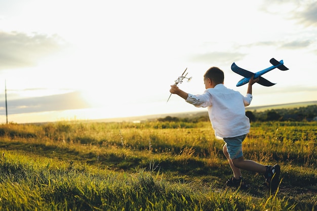 Un enfant sur un champ au coucher du soleil Une enfance heureuse