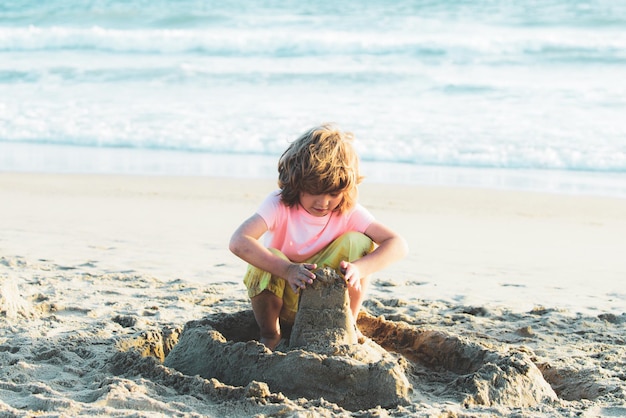 Enfant avec château de sable sur les vacances d'été des enfants sur la plage