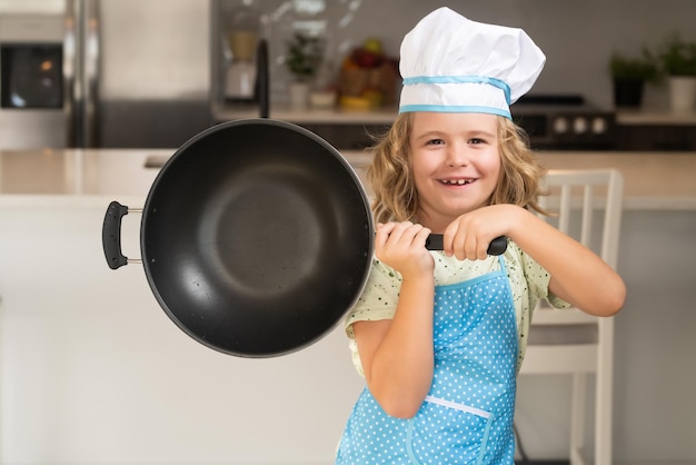 Enfant chef cuisinier cuisine avec casserole dans la cuisine Chef enfant cuisinier cuisson à la maison cuisine Enfant chef cuisinier cuisine