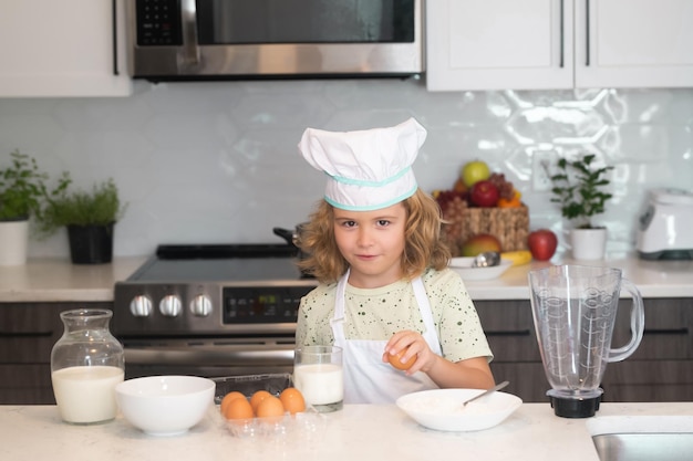 Enfant chef cuisinier cuisine à la cuisine Joli garçon cuisiner dans la cuisine à la maison Cuisine Ingrédients sains Portrait d'un petit enfant en uniforme de cuisinier