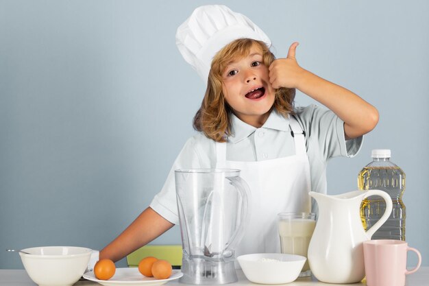 Enfant chef habillé cuisinier tablier de boulanger et chapeau de chef isolé sur fond de studio alimentation saine enfant