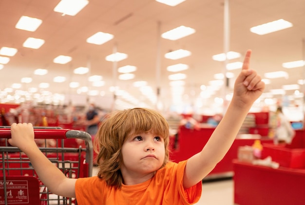 Enfant client holding trolley shopping au supermarché épicerie supermarché shopping avec enfant